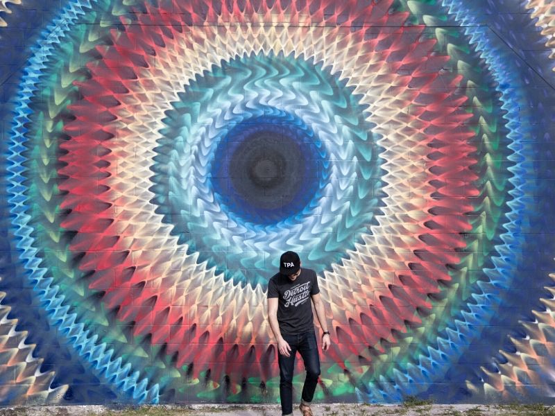 man in front of a standout mural