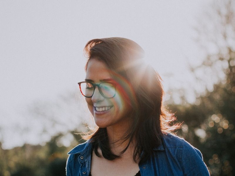 woman smiling with the sun in the background