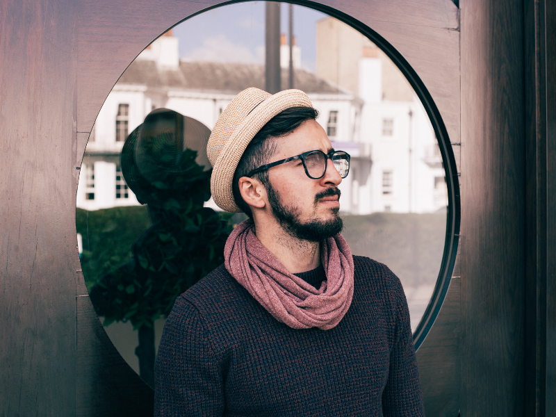 a man stands in front of a barbershop window